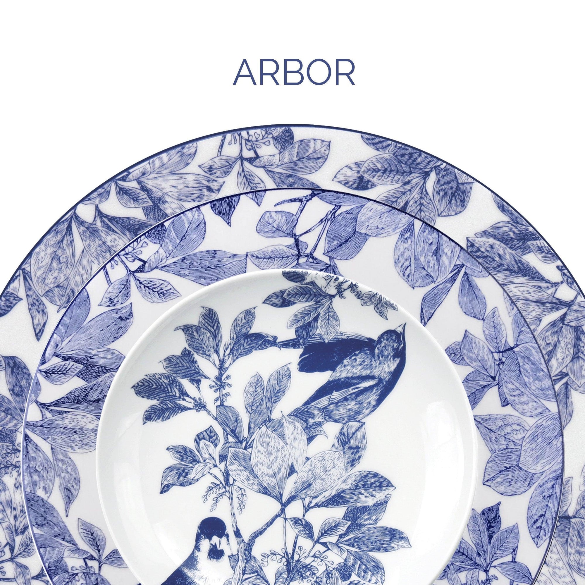 A set of white plates with blue botanical and bird designs, labeled "Arbor" at the top.