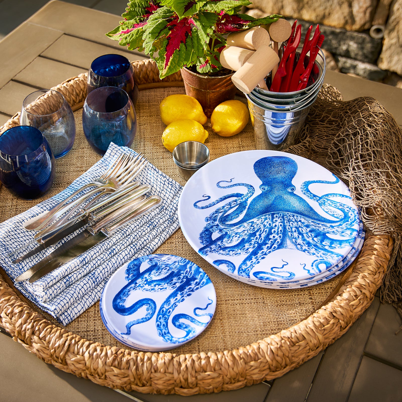 The Lucy Melamine Dinner Plates by Caskata, featuring intricate blue designs, elegantly overlap on a light surface, bringing marine magic to the table setting. This set of four plates adds a touch of seaside charm to any dining experience.