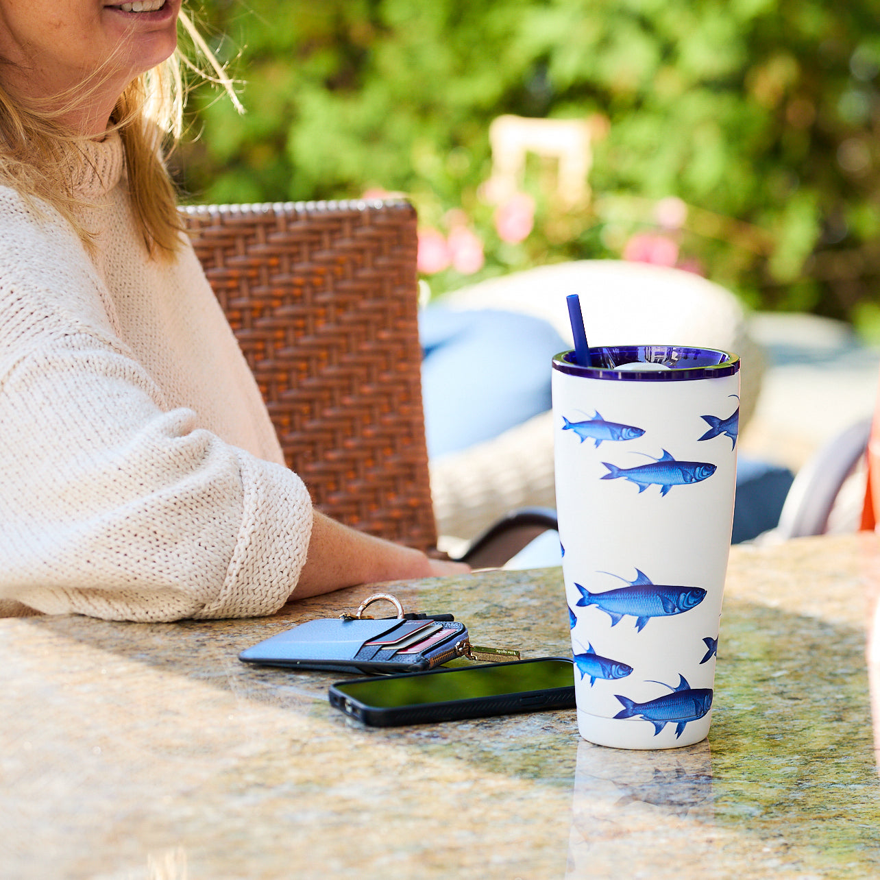 The School of Fish Stainless Steel Insulated Tumbler by Caskata features a white body with a blue fish design and comes with a matching blue straw. This vacuum-insulated drinkware ensures your beverages remain at the ideal temperature.