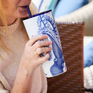 A person sips from a Lucy Stainless Steel Insulated Tumbler by Caskata, decorated with an intricate octopus design.