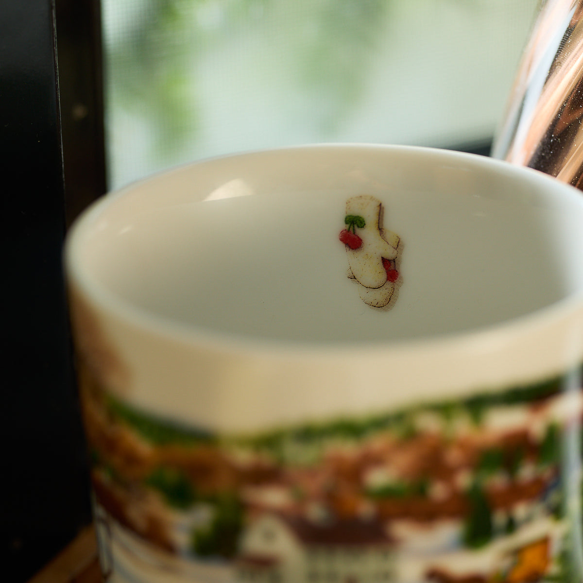 A Caskata porcelain mug from the Winter Wonderland set, embellished with a decorative cookie motif and sprinkles on the inner rim.