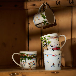 A set of Caskata X Felix Doolittle Winter Wonderland Mugs, featuring four porcelain designs with enchanting winter scenes like ice skaters and a red car in a snowy landscape, are beautifully displayed on a wooden shelf. One of these charming mugs dangles elegantly from a hook above, capturing delicate watercolor-like landscapes that make them ideal for personalized gifts.