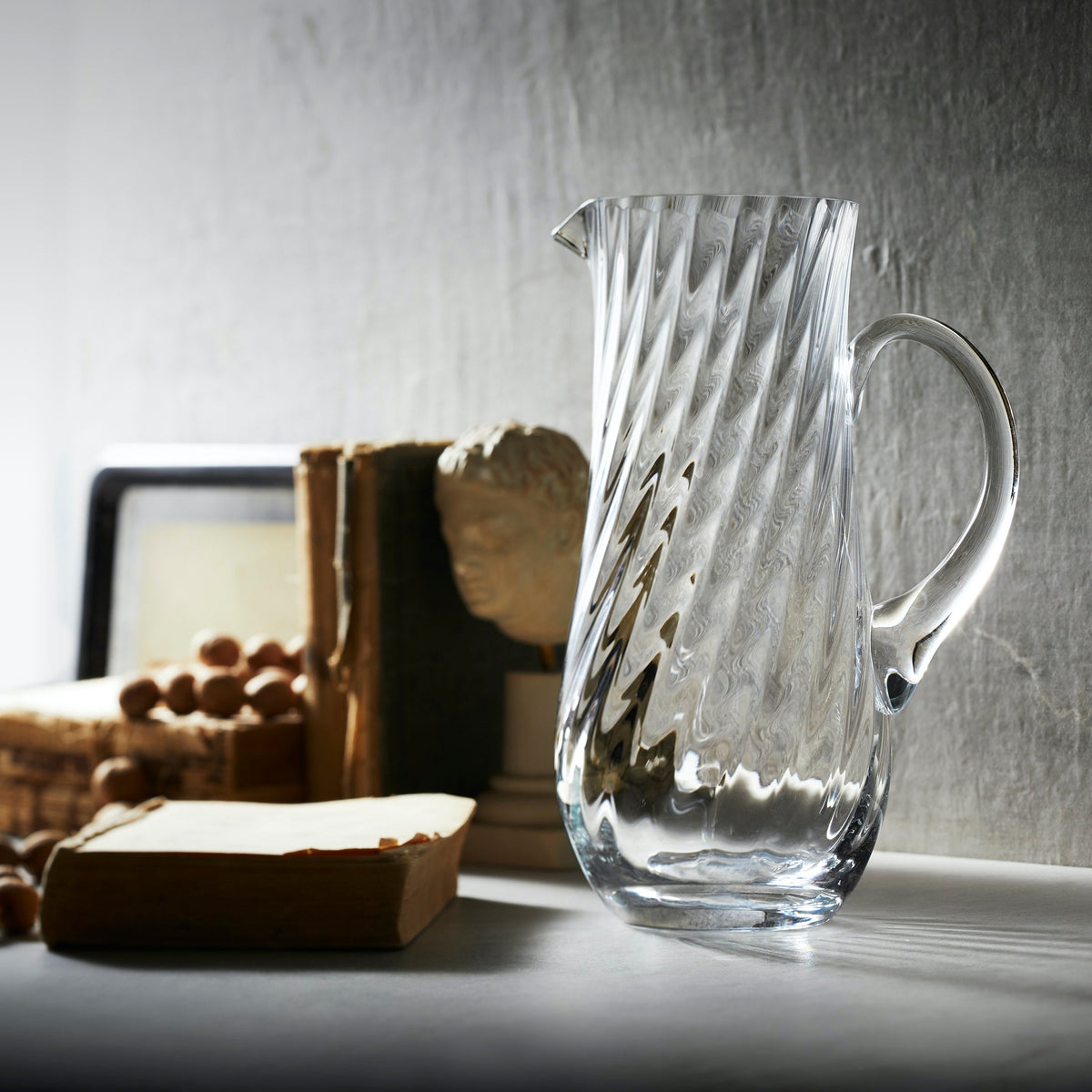 Quinn Clear Mouth-blown Pitcher on a desk