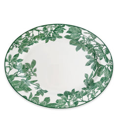 The Arbor Green Oval Rimmed Platter by Caskata Artisanal Home is a round white porcelain piece featuring a contemporary green leaf pattern along the border, seamlessly blending classic and modern high style.