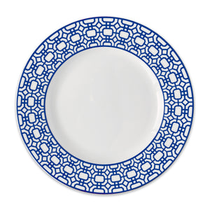 The After Tennis Dinner Bundle by Caskata features a white ceramic plate with a blue geometric patterned rim, perfect for serving elegant salads.