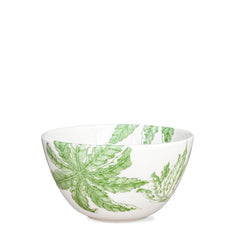 This Freya cereal bowl by Caskata, crafted from white porcelain and adorned with green leaf patterns, offers a blend of elegance and practicality as it is both dishwasher and microwave safe.