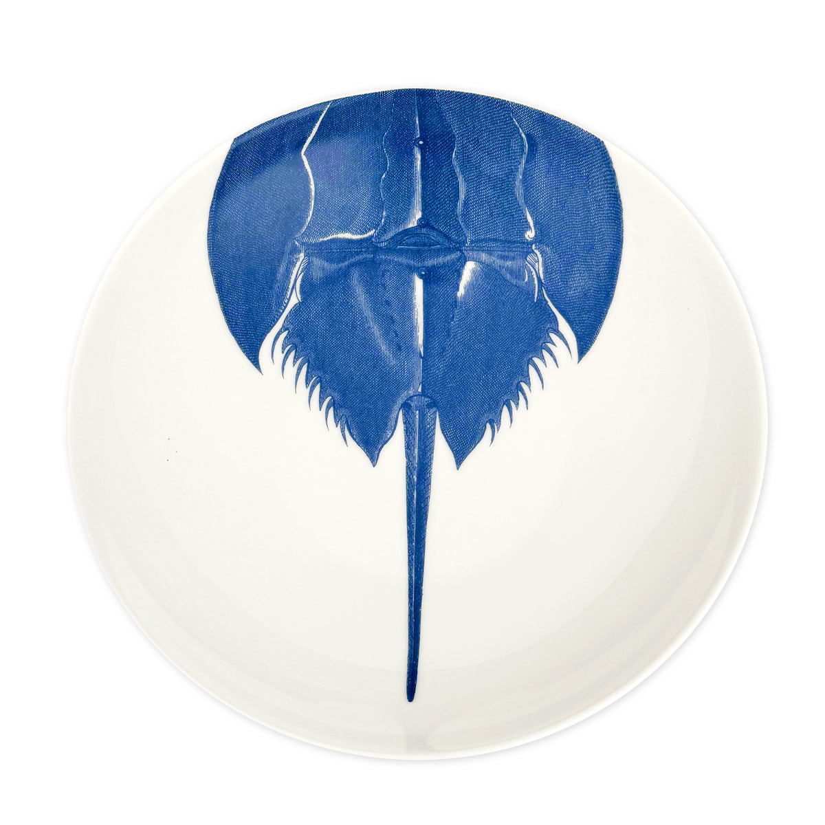 Caskata Artisanal Home&#39;s Horseshoe Crab Wide Serving Bowl is crafted from white high-fired porcelain and adorned with a detailed top-view illustration of a blue horseshoe crab.