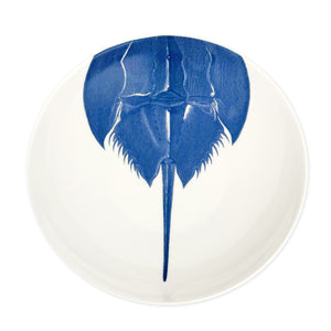 Caskata Artisanal Home's Horseshoe Crab Wide Serving Bowl is crafted from white high-fired porcelain and adorned with a detailed top-view illustration of a blue horseshoe crab.