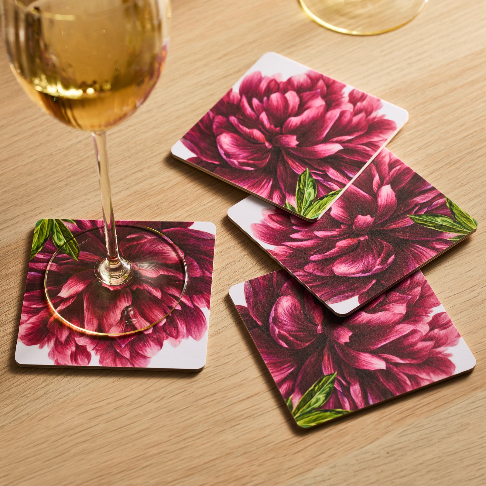 Pink Peony Birchwood Coasters by Caskata feature a front flower design and a branded back. These eco-friendly coasters elegantly rest on a white background.