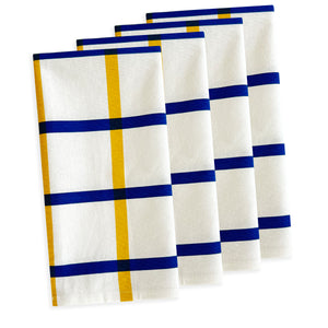 The Clean Lines Essentials Bundle by Caskata, featuring four white dish towels with blue and yellow grid patterns, is ideal for your spring table refresh.