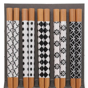 The Nara Chopsticks by Miya, Inc., a set of six pairs featuring diverse black and white patterns on the handles and arranged vertically in a rectangular holder, are an ideal match for sushi trays and entrée bowls.