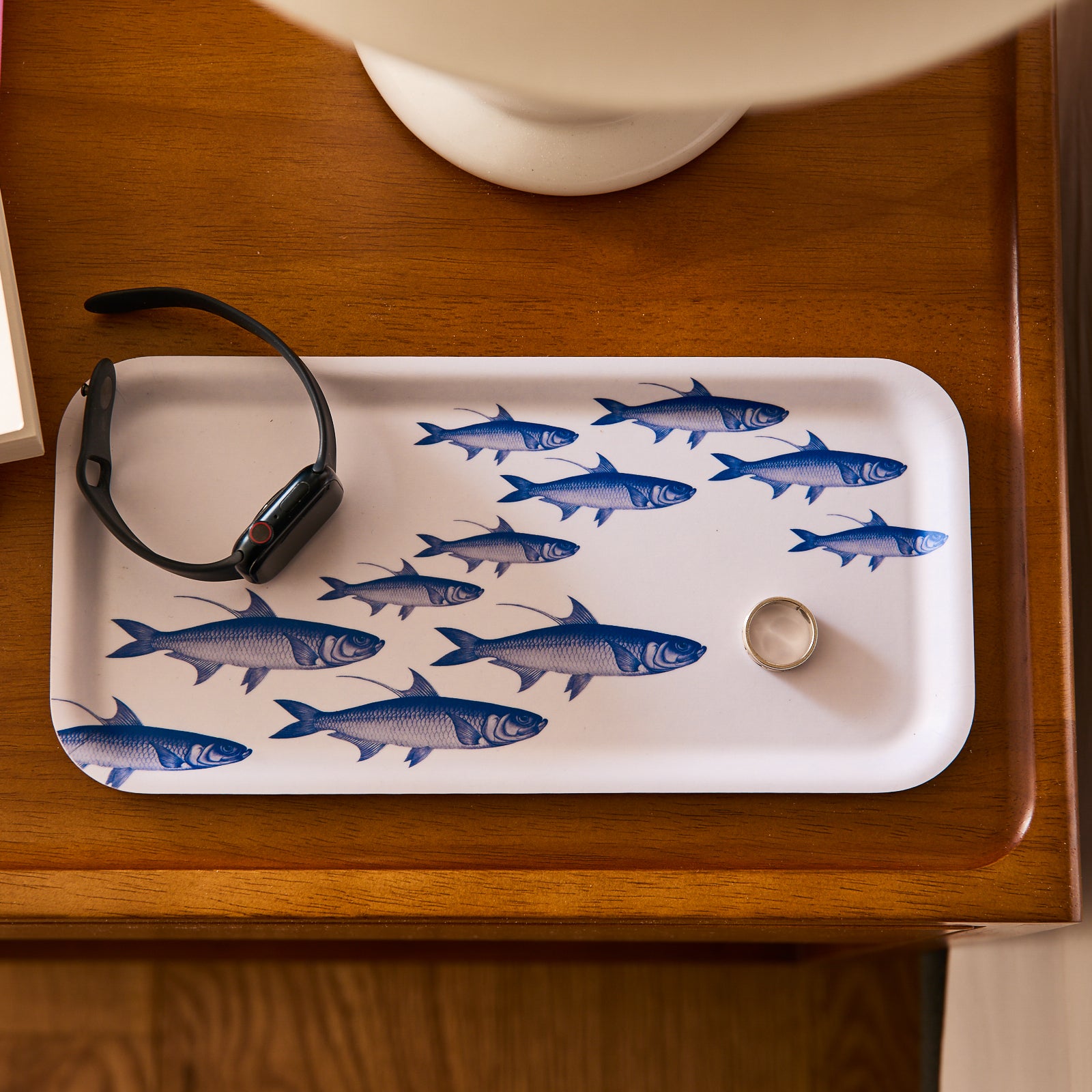 The Caskata School of Fish Small Rectangular Birchwood Tray displays eleven blue fish elegantly swimming to the right against a pristine white background.