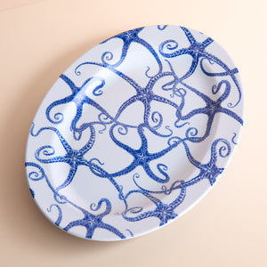 Starfish Melamine Oval Rimmed Platter by Caskata: A BPA-free white plate adorned with a charming blue octopus design.