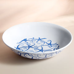 The Caskata Starfish Melamine Serving Bowl features a blue starfish and swirling pattern on white ceramic-style material, perfect for outdoor entertaining with its stylish, durable unbreakable design.