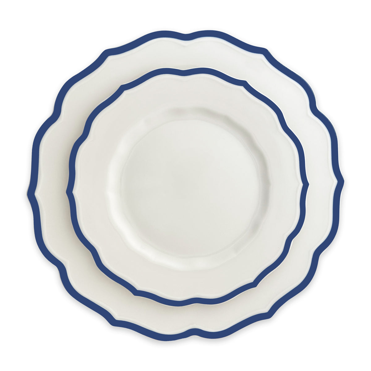 A set of three nested Caskata Stella Scalloped Blue Salad Plates, with white ceramic and blue edges, arranged from largest to smallest, echoing the vintage dinnerware style.