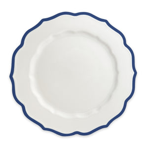 The Stella Scalloped Blue Dinner Plate by Caskata, seen from above, emanates a vintage charm with its wavy blue rim, offering an heirloom-quality dinnerware aesthetic.